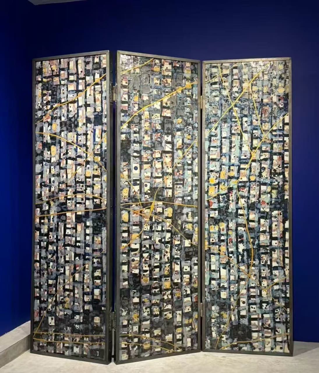 Grey and black porcelain screen with gold lines in a spatial setting