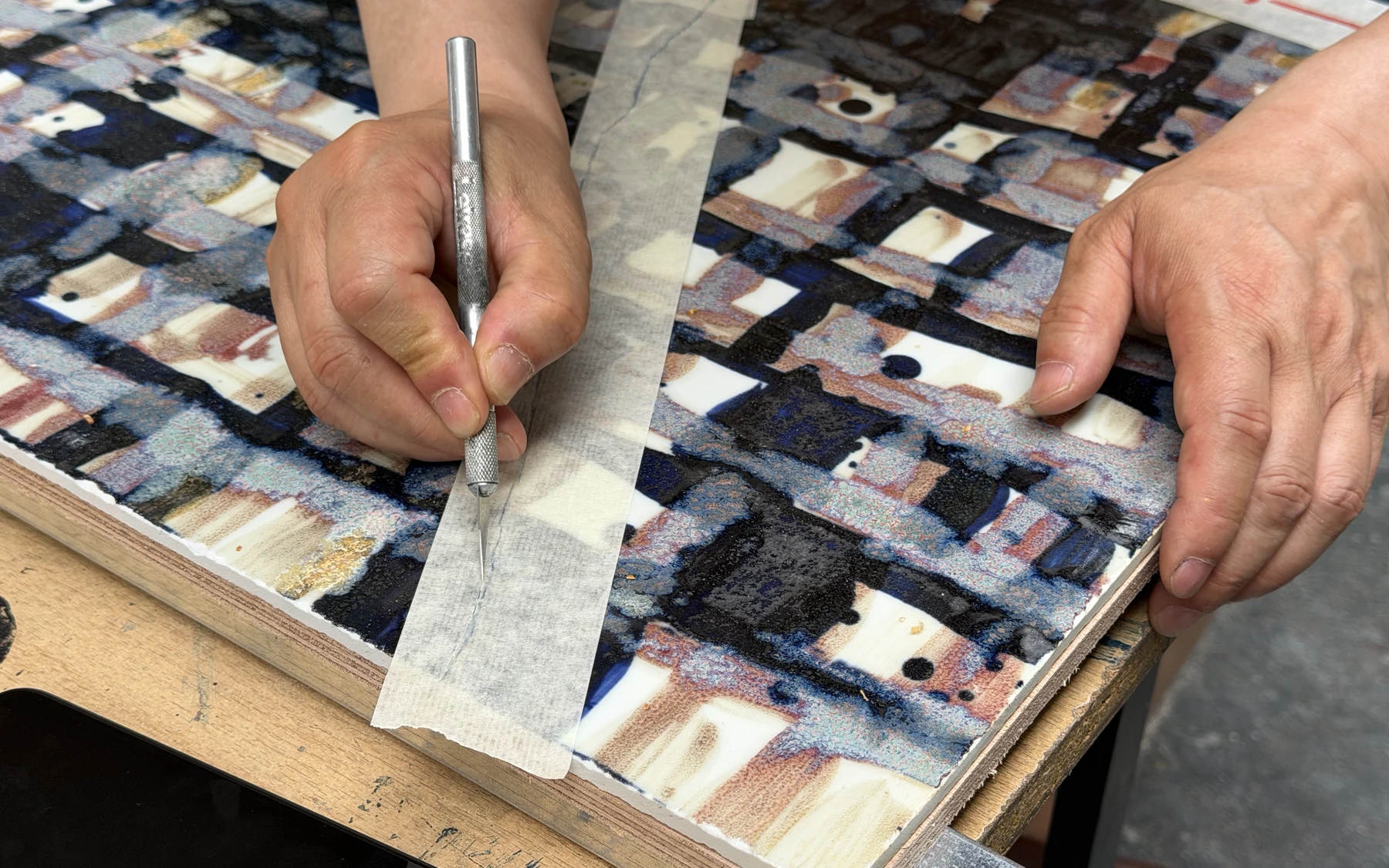 Hands and tool working on the panel surface